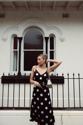 a lady in a black slip dress with white polka dots
